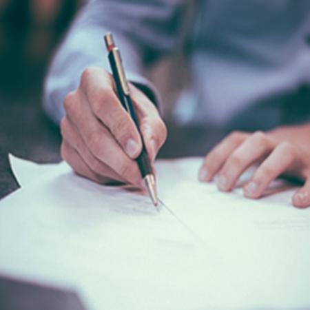 A close up of a hand writing with a pen.
