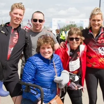 Alli and her family posing outdoors at MS Bike wearing MS Bike jerseys.